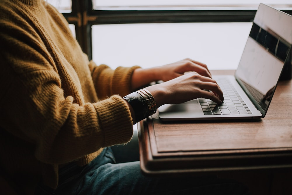 a person typing on their laptop.